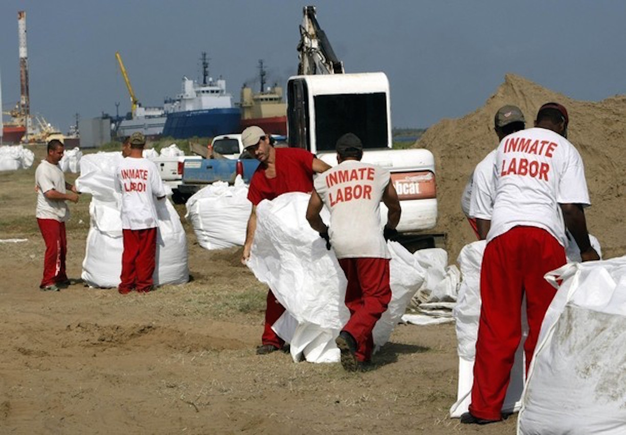 Inmates from a La Fourche parish jail on a work release program fill giant sandbags in Port Fourchon, Louisiana May 11, 2010. U.S. Army National Guard troops were dropping the sandbags using helicopters on nearby breaks in beaches to protect marshes from the BP oil spill offshore. REUTERS/Rick Wilking 